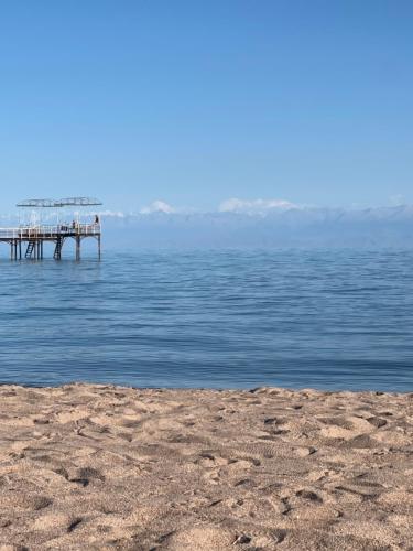 a pier in the middle of a body of water at Кыргызское Взморье Иссык-Куль, Issyk - Kul, Bosteri, Kyrgyz vzmorie in Bosteri