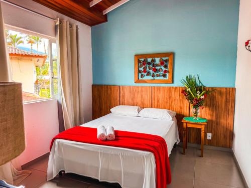 a bedroom with a bed with a red blanket at Pousada Portal de Paraty- COM GERADOR DE ENERGIA in Paraty