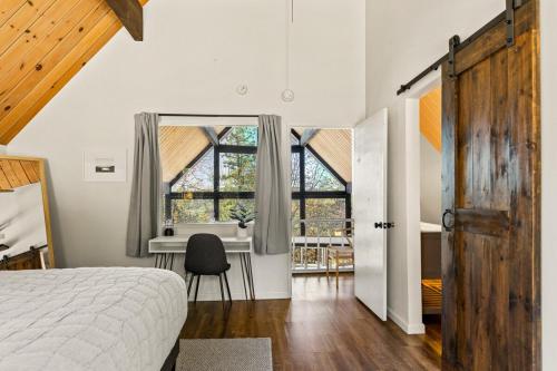 a bedroom with a bed and a desk and a window at The Crown A-Frame Gated Central AC Lake Access in Lake Arrowhead