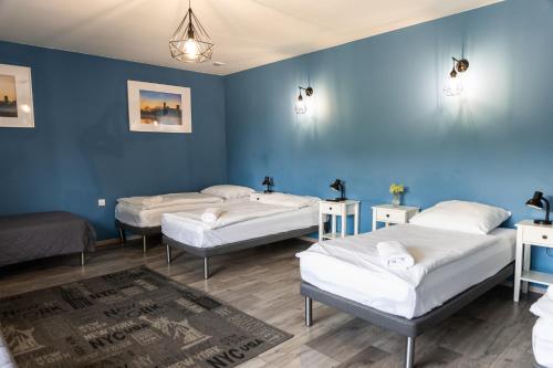 three beds in a room with blue walls at Ostoja Czersk Zamek Góra Kalwaria in Czersk