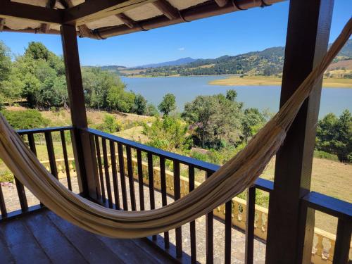 a hammock on a porch with a view of a lake at Casa Campestre Bimori in Chocontá