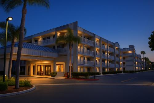 a large building with palm trees in front of it at Motel 6-Anaheim, CA - Maingate in Anaheim