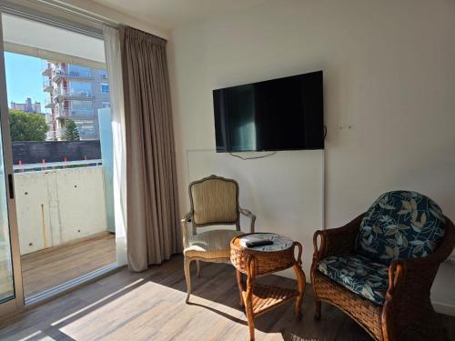 Una sala de estar con dos sillas y un televisor de pantalla plana. en Apartment Belgrano, en Buenos Aires