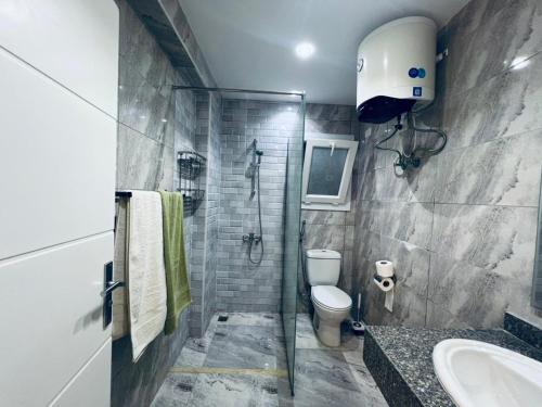 ein Badezimmer mit Dusche, Toilette und Waschbecken in der Unterkunft One bedroom and reception in Hurghada