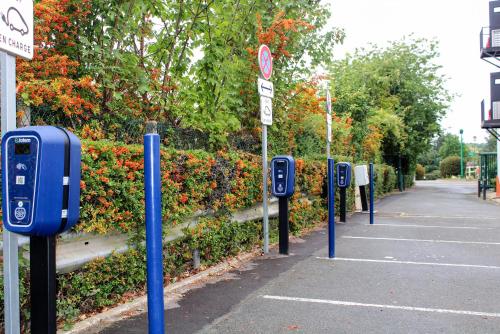 a row of parking meters in a parking lot at Première Classe Plaisir Gatines in Plaisir