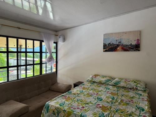 a bedroom with a bed and a couch and a painting at Casa Quinta Vereda San Nicolas La Mesa in La Mesa