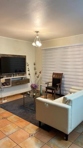 Una sala de estar con un sofá y un televisor de pantalla plana. en Apart Rayen, en Los Ángeles