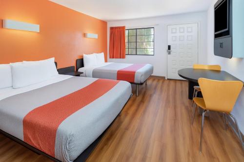 a hotel room with two beds and a table at Motel 6-Thousand Oaks, CA in Thousand Oaks