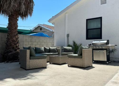a patio with couches and a grill next to a house at Coastal Escape in Redondo Beach in Redondo Beach