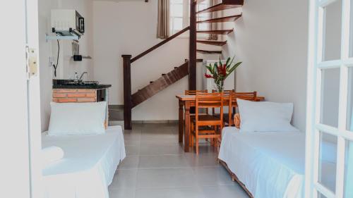 a living room with two beds and a table at Pousada Portal de Paraty- COM GERADOR DE ENERGIA in Paraty