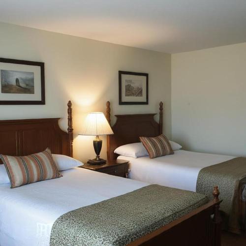 a hotel room with two beds and a lamp at Midtown Inn in Saskatoon