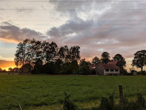 a house in the middle of a field at sunset at Ferienwohnung Seeling Weserbergland in Ottenstein