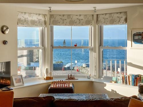 een woonkamer met een groot raam met uitzicht op de oceaan bij Ocean Breezes in St Ives