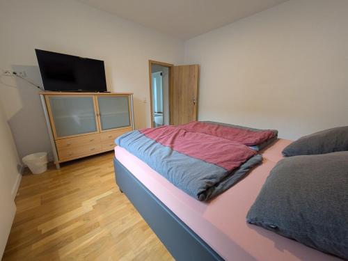 a bedroom with a bed and a flat screen tv at Ferienwohnung Seeling Weserbergland in Ottenstein