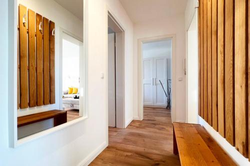 a hallway with a mirror and a room with a bed at Aesten Mare Kühlungsborn Apartment 1 in Kühlungsborn