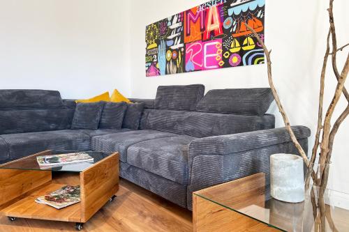 a living room with a black couch and a table at Aesten Mare Kühlungsborn Apartment 1 in Kühlungsborn