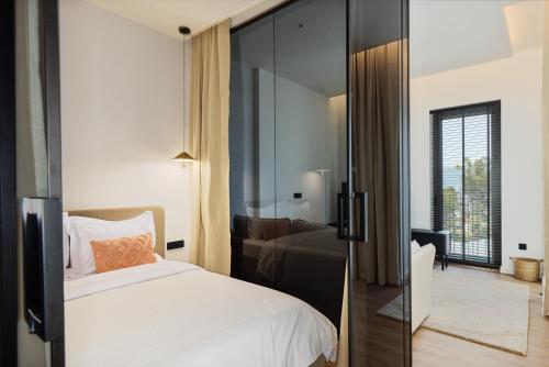 une chambre avec un lit et une porte coulissante en verre dans l'établissement Boka Place Porto Montenegro-sea view, à Tivat
