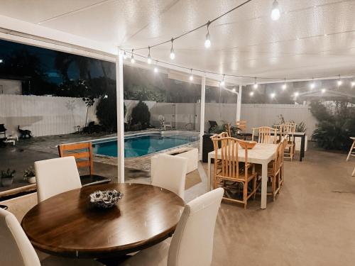 a dining area with a table and chairs and a pool at The blue Homestay near Miami Airport in Miami