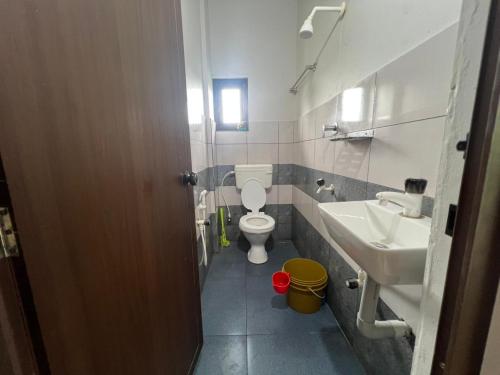 a small bathroom with a toilet and a sink at Mundodan complex in Nilambūr