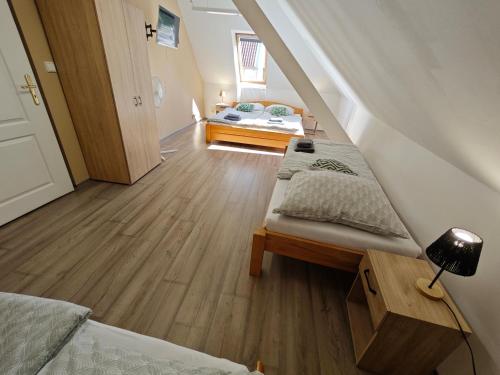 a attic room with two beds and a bedroom at Apartmány Zámecká in Roudnice nad Labem
