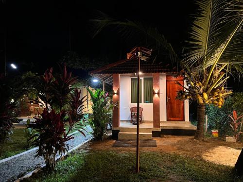 a small house at night with a sign in front of it at Lake Homes in Varkala