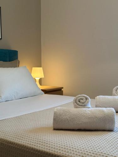 a hotel room with a bed with towels on it at Dioni Apartments in Plataria