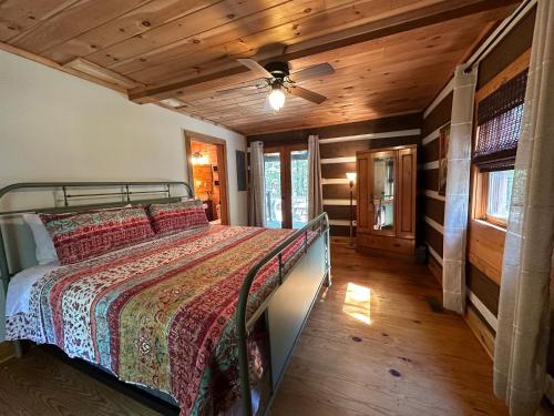 una camera da letto con un letto e un ventilatore a soffitto di Eclectic Cabin - 5 Mins to DeSoto Park & Falls 
