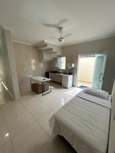 a bedroom with a bed and a kitchen in a room at Casa Tulipas in Holambra