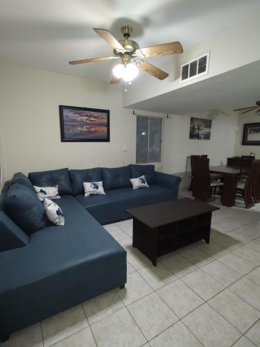 sala de estar con sofá azul y ventilador de techo en Valle del Sol, en Senecú