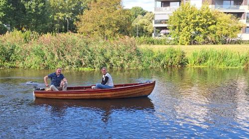 two people sitting on a boat in the water at B&B De SluisPod in Hoogeveen