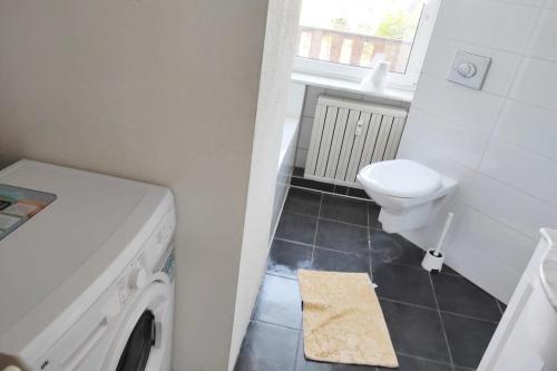 a bathroom with a washing machine and a toilet at Nice apartment with balcony & garden N1L in Zeitz