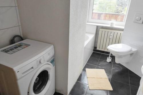 a bathroom with a washing machine and a toilet at Nice apartment with balcony & garden N1L in Zeitz