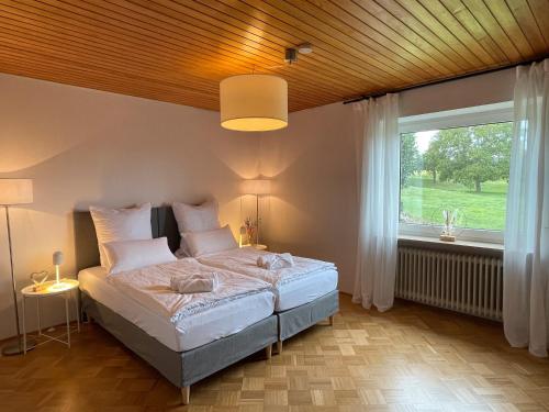 a bedroom with a bed and a large window at Hesselberg-Oase Ferienhof Hüttner in Röckingen
