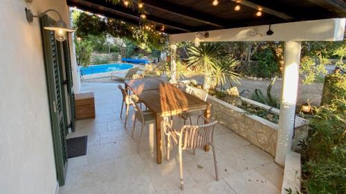 a patio with a table and chairs under a pergola at Cosy Getaway in Gostinjac