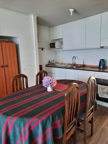 una cocina con mesa y sillas con flores. en Energía del Sur, en Puerto Montt