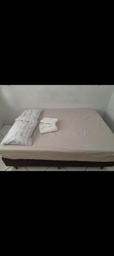 a bed with two white towels on top of it at Casa Bela Vista in Blumenau