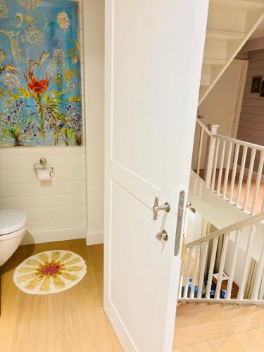 a bathroom with a toilet and a painting on the wall at A Calm & Quiet Stay in Wuustwezel