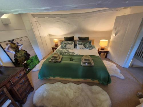 ein Schlafzimmer mit einem großen Bett in einem Zimmer mit einem großen in der Unterkunft Manor Cottage in Downton