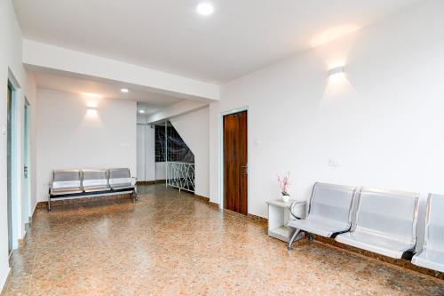 a row of chairs in a hallway with white walls at Hotel O Vaisravana in Gangtok