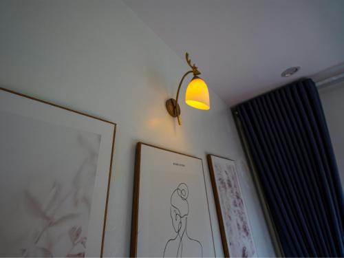 a light on a wall with pictures on it at Strawberry House , Tour & Motorbikes Rentel in Ha Giang