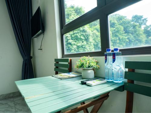 a blue table with bottles and a window at Strawberry House , Tour & Motorbikes Rentel in Ha Giang