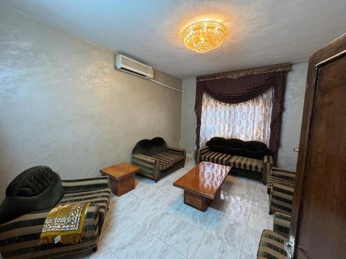 a living room with couches and a table at Urban Nest Apartment-Furnished & Modern in Jerash