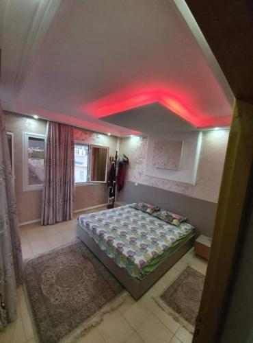 a bedroom with a bed with red lights on the ceiling at Villa Escapade, bord de mer à RAFRAF in Rafrāf