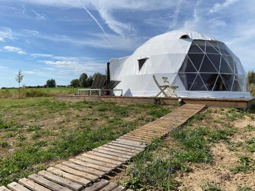 a large dome tent sitting in a field at Maya Lena dome in Belleghem