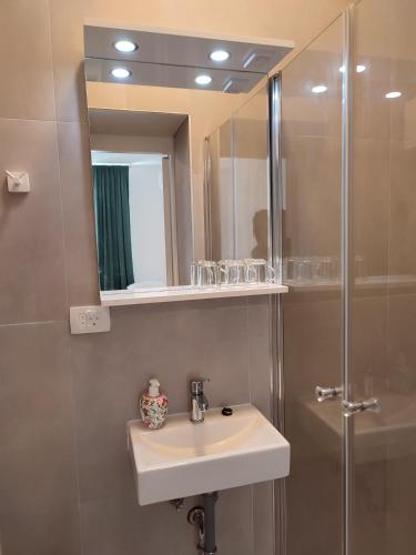 a bathroom with a sink and a shower with a mirror at Beach Villa Selce in Selce