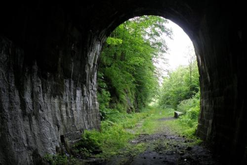an archway in a stone tunnel with a dirt road at Apartament w Sercu Gór z ogrodem in Wałbrzych