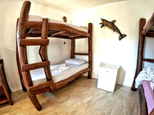 a room with two bunk beds and a fish on the wall at Morro Beach Hotel in Morro de São Paulo
