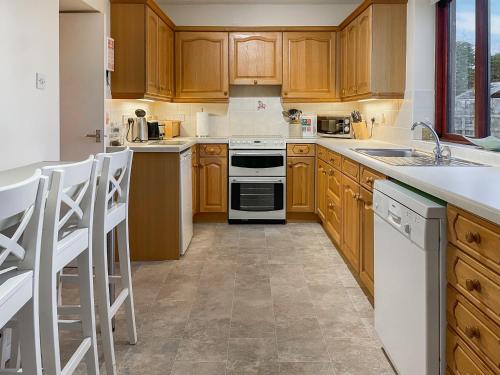 a kitchen with wooden cabinets and white appliances at The Martin's - Uk48870 in Belford