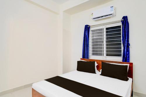 a bedroom with a bed and a window at Super Hotel O Ghatkesar Railway Junction Formerly Kakatiya Grand in Bībīnagar