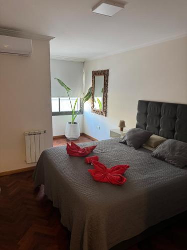 a bedroom with a bed with red flowers on it at SkyHome Córdoba, Terraza y Piscina Panorámica in Córdoba